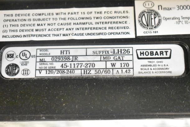 2017 Hobart HTi-LH26 metal commercial scale tag showing model, voltage, and testing details.