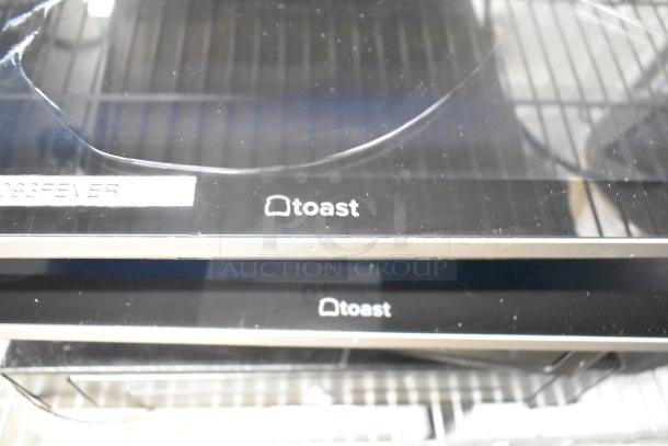 10 various items, including Toast-branded POS monitors, used condition, featuring signage and visible scuffs.