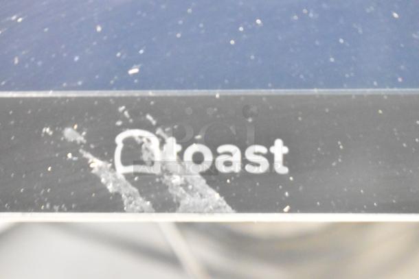 Toast POS monitor close-up with visible logo; part of auction lot including 10 items like 5 monitors, 2 cash drawers.