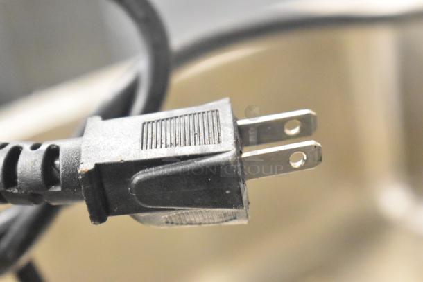 Plug detail of 2017 Nemco 6055A Countertop Food Warmer, 120V, 1 Phase, with black power cord and pronged plug.