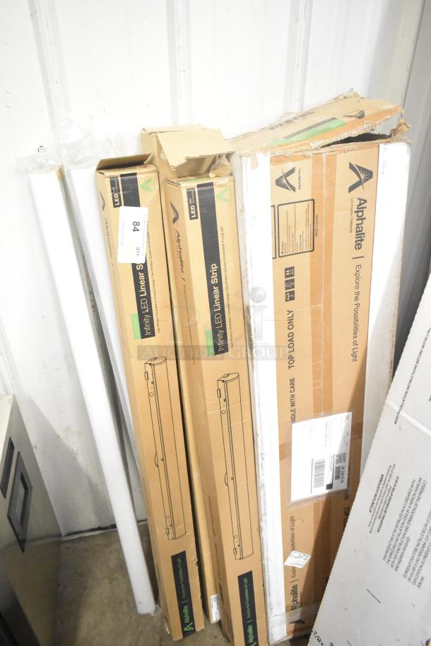7 brand new Alphalite Infinity LED Linear Strips in boxes with minor scratches and dents. Boxes labeled for care.