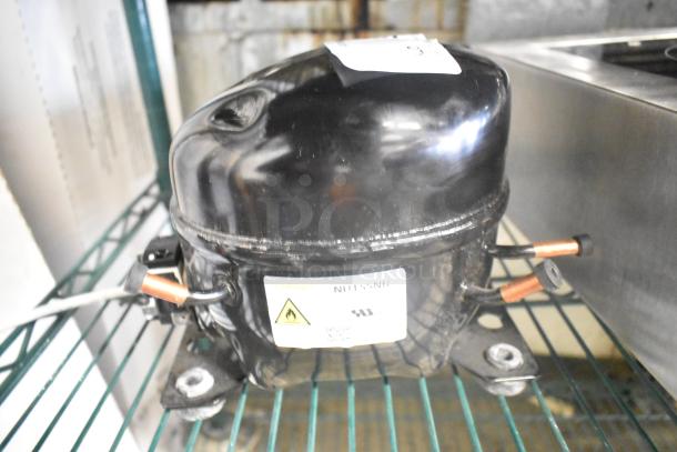 Cubigel NUT55NR compressor, black, 151-127 volts, 1 phase, showing label and copper fittings.