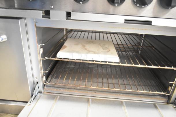 Mainstreet 541E60N 10 burner gas range with 2 ovens, over shelf, and backsplash. Visible interior detail showing oven racks.