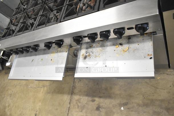 Mainstreet 541E60N 10-burner range, natural gas, with dual ovens, over shelf, back splash; visible residue on surface.