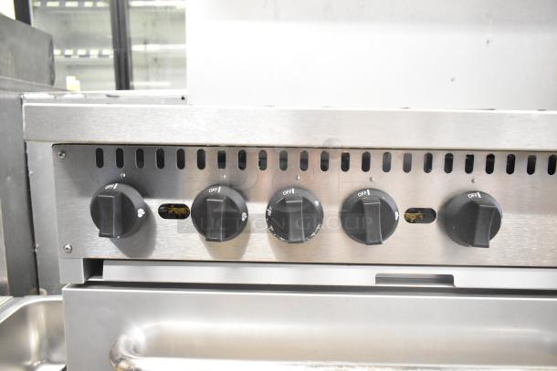 Mainstreet 541E60N range panel with 5 control knobs, stainless steel finish; part of 10-burner gas range with ovens.