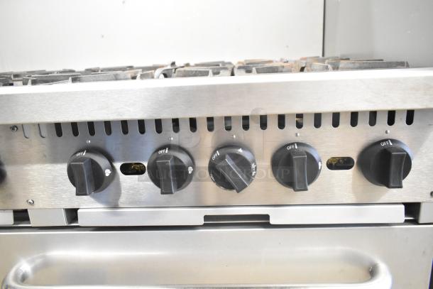 Mainstreet 541E60N commercial range, 10 burners, 2 ovens, natural gas, visible control knobs, over shelf, used condition.