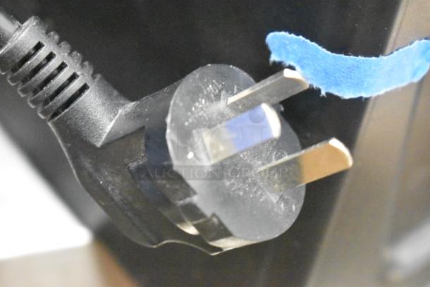 Blantyre Q8 plug close-up; 220V, 1 Phase. Black cord attached to the appliance, blue tape next to plug.