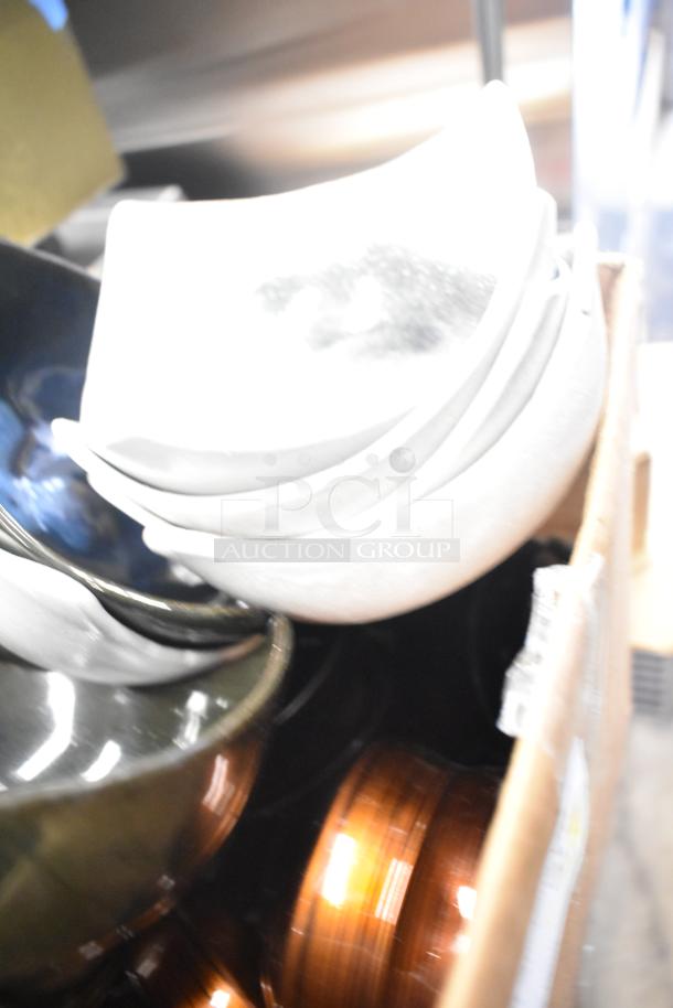 Lot of ceramic bowls, vases, and poly trays in assorted colors, stacked in a box. Items appear in good condition.