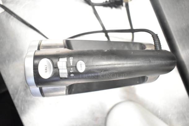 Aicok HM833 hand blender in black, features speed dial and eject button, light use, shown cord attached.