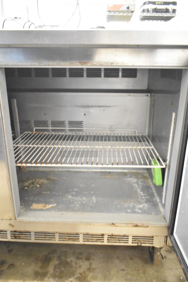 Beverage Air WTR60A 2-door undercounter cooler with commercial casters, 115V, shows wear, interior shelf visible.