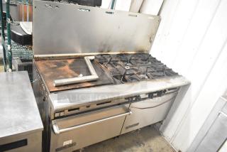 American Range commercial gas 6-burner range with flat top griddle, 2 ovens, and backsplash. Visible wear, stainless steel.