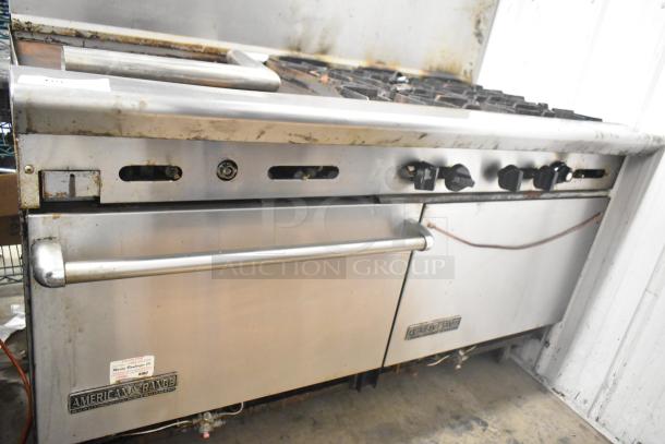 American Range commercial gas 6-burner range with flat-top griddle, two ovens, backsplash; shows signs of use.