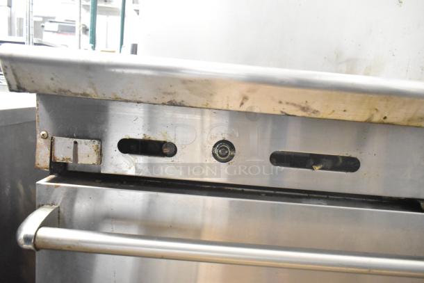 American Range commercial gas stove, featuring a 6-burner cooktop, flat top griddle, 2 ovens, and backsplash. Used condition.