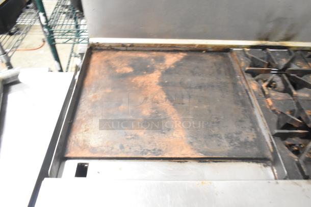 American Range commercial gas range with 6 burners, flat top griddle, 2 ovens, and backsplash. Used condition.