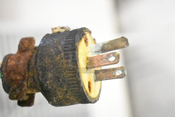 Rusted and worn electrical plug with exposed prongs, showing significant corrosion and damage.