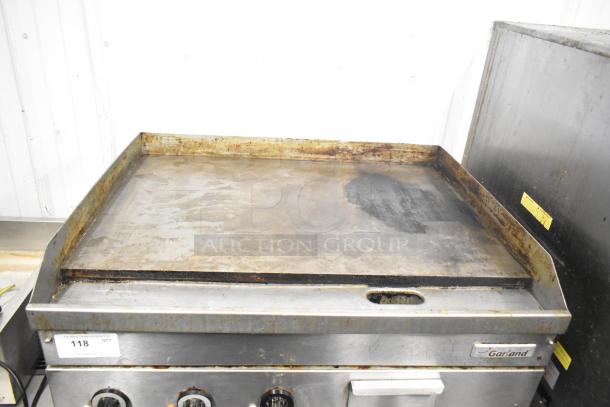 Garland E24-36G commercial countertop electric griddle, 208 volts, 1/3 phase, visible wear on cooking surface, includes control knobs and drip tray.