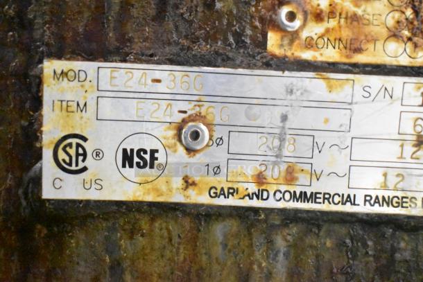 Garland E24-36G commercial griddle label showing model E24-36G, 208V, 1/3 phase. CSA, NSF certified, rust visible.
