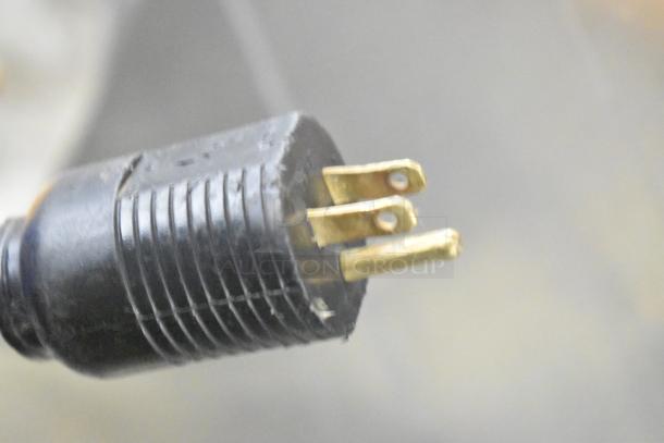 Close-up of a three-prong power plug for the JBT 2ND-GEN-MFJ-HE citrus juicer, showing a standard 115V connection.