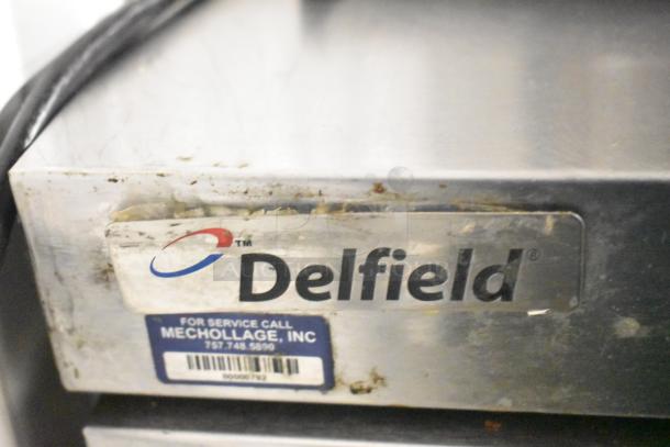 Delfield D4448N-18M-A22 prep table with visible branding and service sticker, showing wear. 115 volts, 1 phase, 4 drawers.
