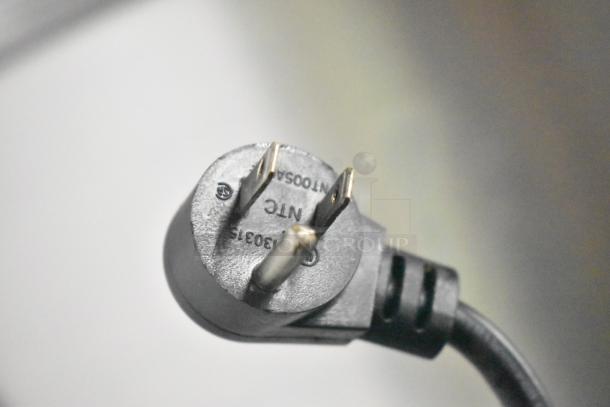 Close-up of a three-prong electrical plug labeled with manufacturer's details, compatible with the Delfield D4448N-18M-A22 model.