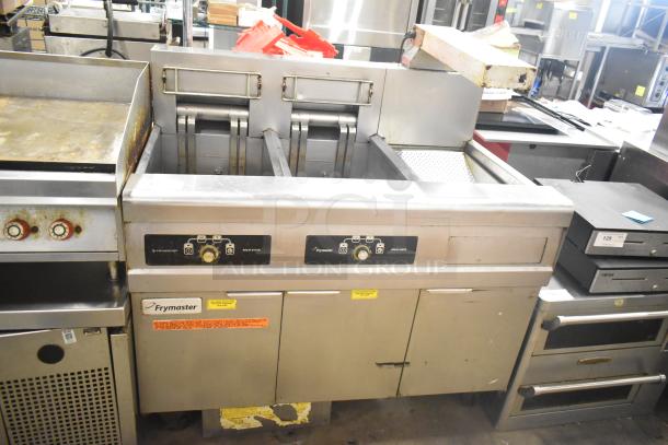 Frymaster 2-bay deep fat fryer with dumping station, filtration system, and commercial casters. Used condition.