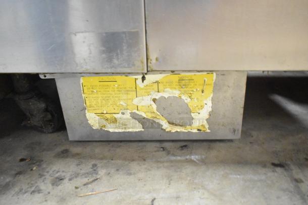 Frymaster commercial 2-bay fryer with dumping station and filtration, on casters. Visible worn caution label on the base.