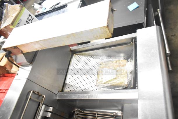 Frymaster 2-bay deep fat fryer with dumping station, filtration system, and commercial casters. Some signs of use visible.