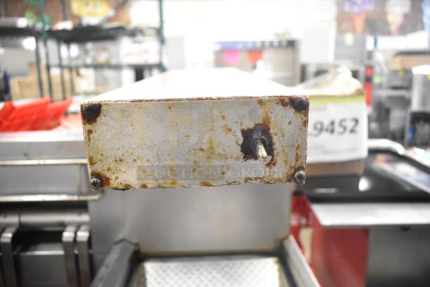 Frymaster 2 Bay Deep Fat Fryer, visible rust and wear, includes dumping station and filtration system, on commercial casters.