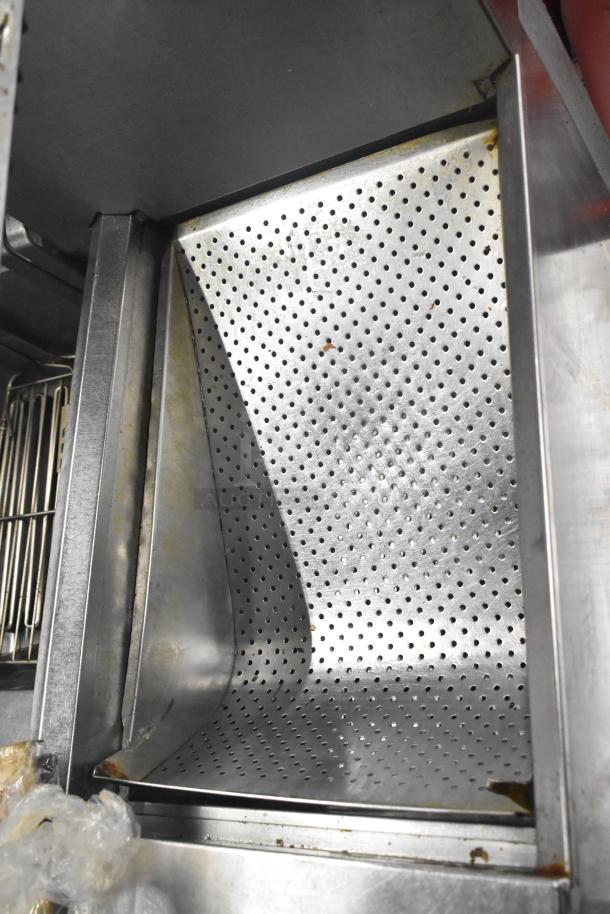 Frymaster 2 Bay Deep Fat Fryer with perforated metal components, showing commercial casters and filtration system.