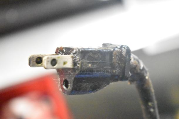 The image shows a close-up of a power plug, not the Frymaster fryer described.