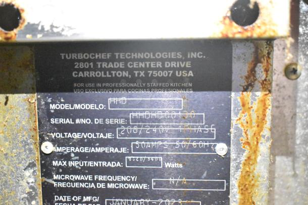 2023 Turbochef HHD commercial oven label with model, serial number, voltage, amperage. Minor rust visible on the surface.