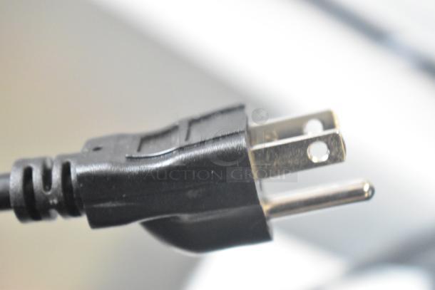 Close-up of a black electrical plug with two metal prongs, part of Vissani DCM7QWBWW chest freezer, 115 volts, 1 phase.