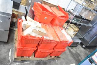 13 red poly bins filled with napkins, holding bin drop-ins, cups, and utensils, stacked on a pallet. Auction lot.