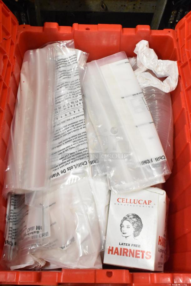 Red poly bin with plastic bags, Cellucap hairnet box, and various packaging, in good condition for auction.