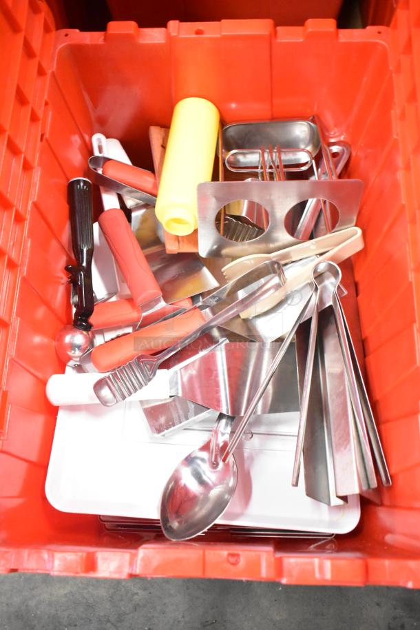 Red poly bin filled with assorted utensils, napkins, and holding bin drop-ins. Includes spoons, tongs, and a bottle.