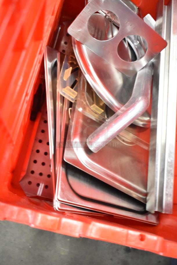 Red poly bin filled with metal trays and inserts, includes napkins, cups, and utensils. Auction offers 13 bins total.