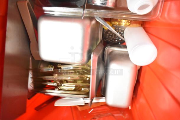 13 red poly bins with contents including napkins, cups, utensils, and dedicated holding bin drop-ins. Auction lot.