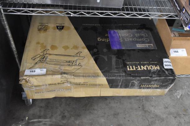 Mount-it! Compact Standing Desk Converter in original box. Box shows signs of wear with labels, indicating item number 165.