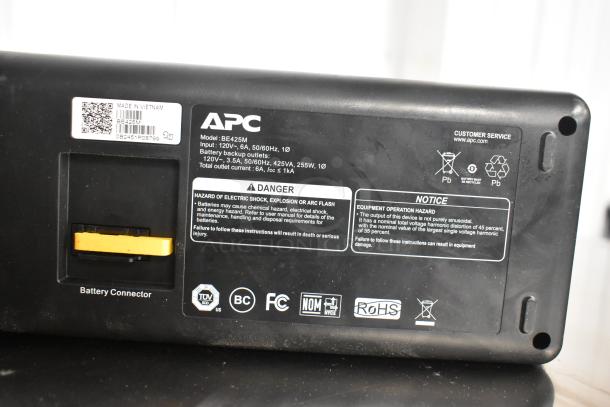 APC Uninterruptible Power Supply, Model BE425M, 120V input, battery backup, in used condition, safety and operation labels visible.