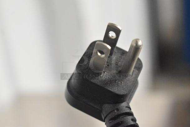 Close-up of a power plug for an APC Uninterruptible Power Supply, showing prongs and slight wear.