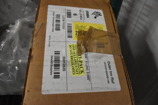 Tiered lot of cleaning supplies in cardboard box, visible labels show Zebra Technologies and shipping details.