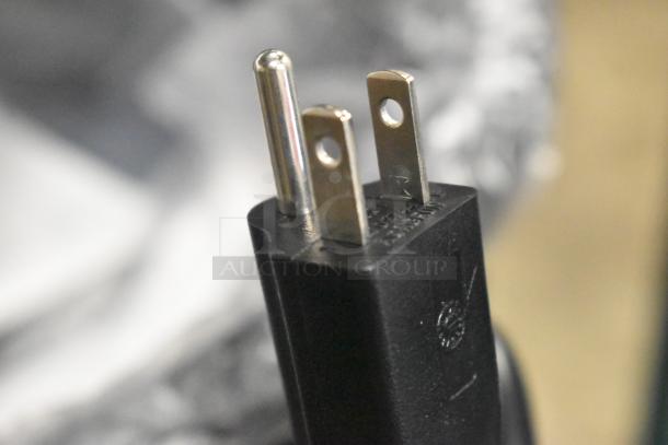 Close-up of a plug from the Avantco 177RCB60 electric rice cooker, showing a standard three-prong design. Markings visible on plug surface.