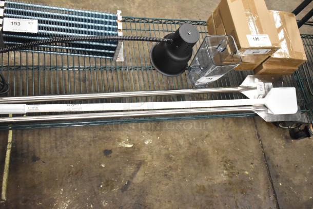 Four brand new items, including 2 Fourté 483SMP48 stainless steel paddles and Carlisle 4035300 Sparta nylon paddle, plus a poly blender pitcher, displayed on a metal cart.