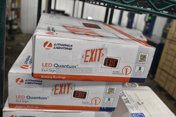 Stack of Lithonia Lighting LED Quantum Exit Signs in original packaging. Features battery backup, dual voltage 120/277V.