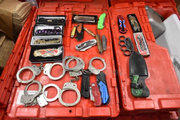 Lot of 25 items including handcuffs, brass knuckles, pocket knives; various designs and conditions in boxes.