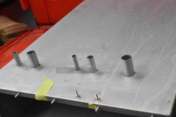 Metal box with multiple protruding metal tubes on top; structural integrity appears intact, minimal surface wear.