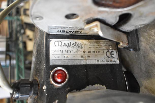 Magister M MD LA espresso grinder base, no hopper, 115 volts, 1 phase, red power light, worn exterior, model label visible. Made in Italy.