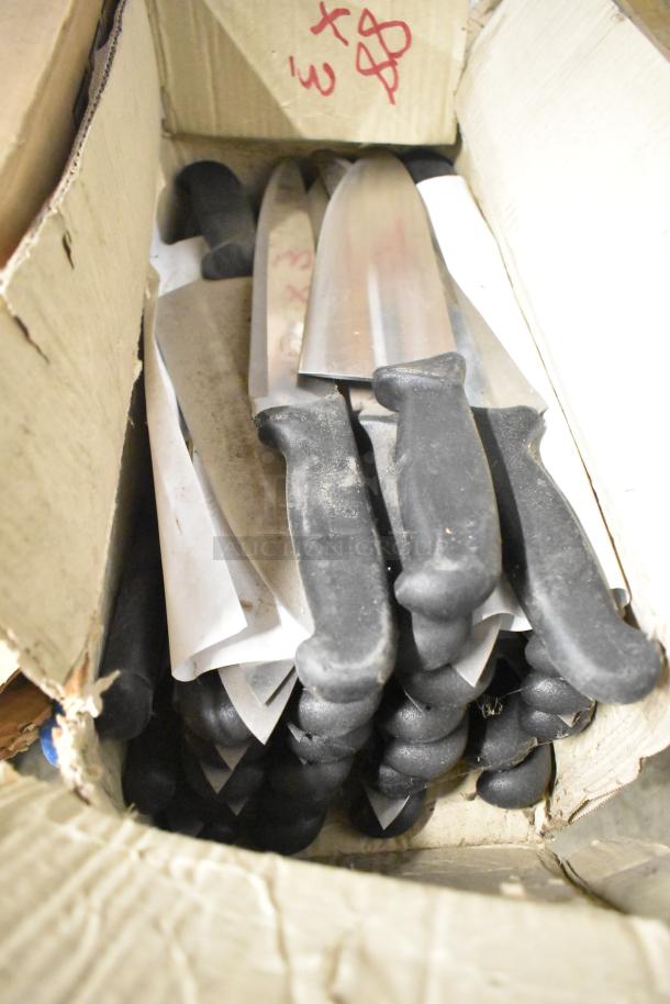 Box of 80 sharpened stainless steel knives, including chef knife. Black handles, good condition, in cardboard packaging.