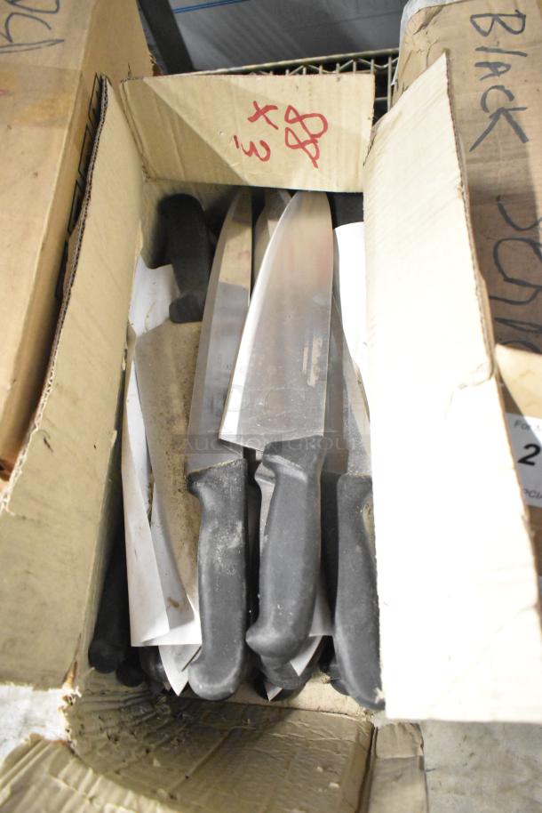 Box of 80 sharpened stainless steel knives, including chef knives, with black handles. Good condition, multiple units.