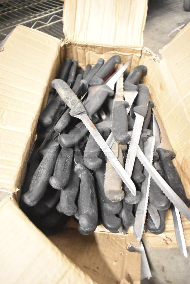 Box of 100 sharpened stainless steel knives, including serrated and chef knives, with black handles, in good condition.